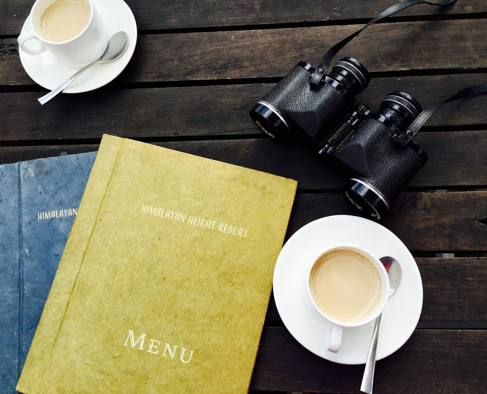 image with cup of tea, professional note books and a pair of black binoculars